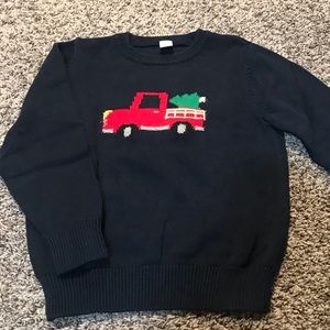 Red holiday truck with tree holiday sweater.